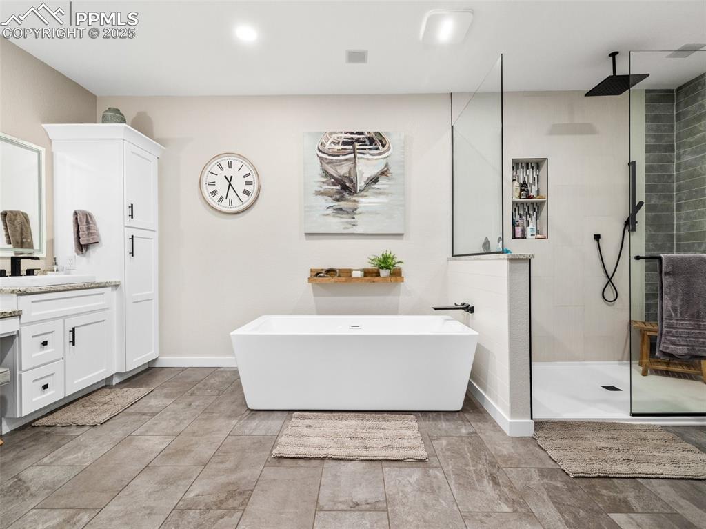 Image 33 of 48: Full bath featuring vanity, a freestanding tub, and walk in shower