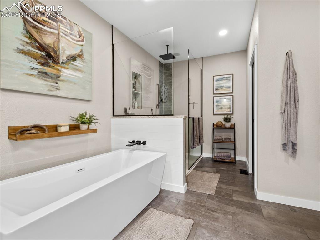 Image 35 of 48: Full bathroom featuring a stall shower, a freestanding bath, and recessed l