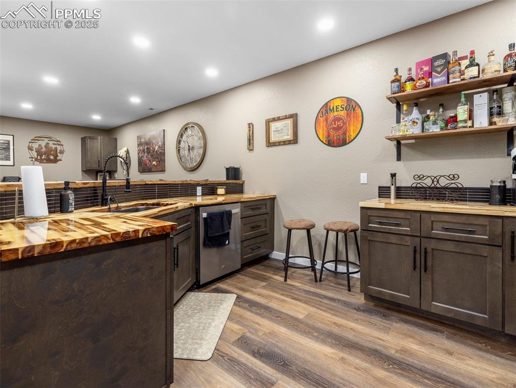 Image 41 of 48: Kitchen featuring wood counters, dark brown cabinets, wood finished floors,