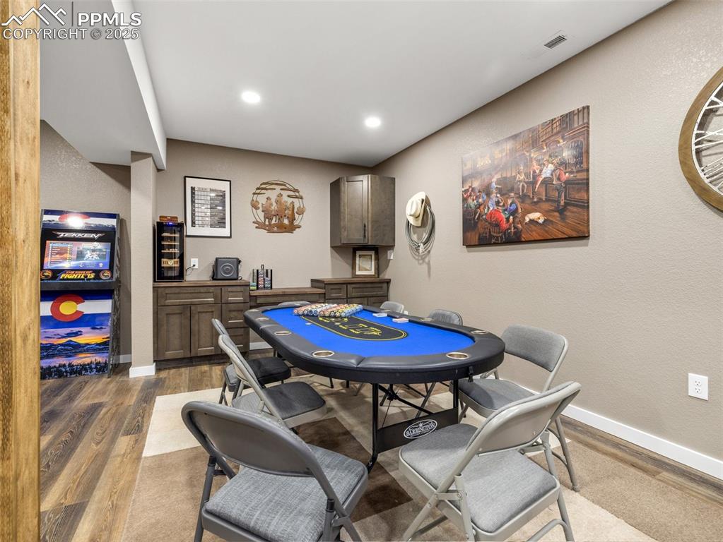 Image 43 of 48: Game room with wood finished floors, a dry bar, and recessed lighting