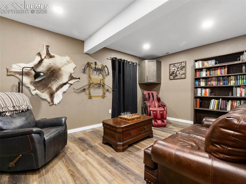 Image 44 of 48: Living area with light wood-style flooring, beamed ceiling, and recessed li