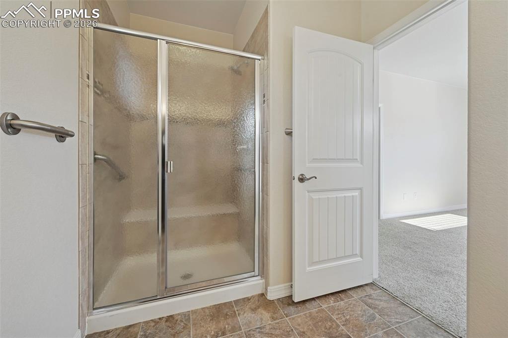 Image 25 of 41: Primary shower with seating area.  Tub located in secondary bathroom