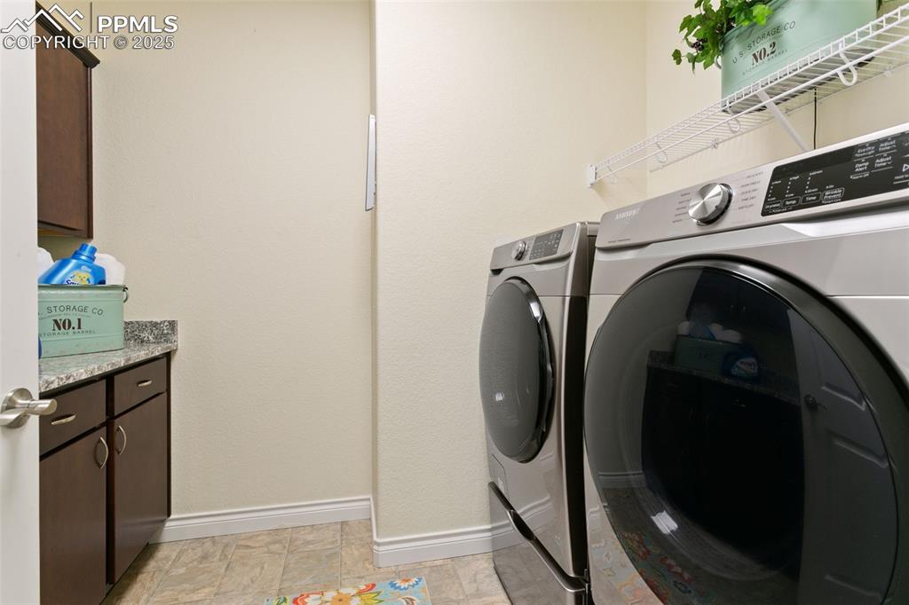 Image 12 of 49: Laundry area with washing machine and dryer and baseboards