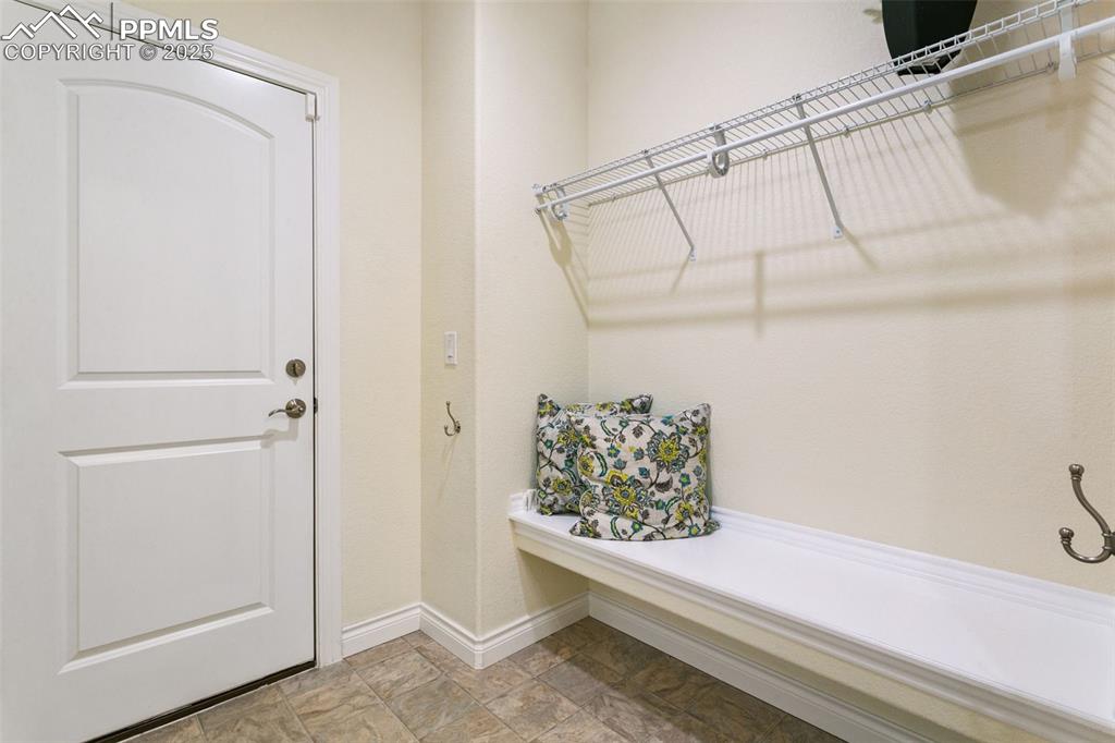 Image 14 of 49: Mudroom featuring dropzone and bench