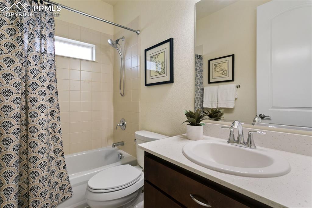 Image 17 of 49: Bathroom with shower / bath combination with curtain, vanity, and a texture