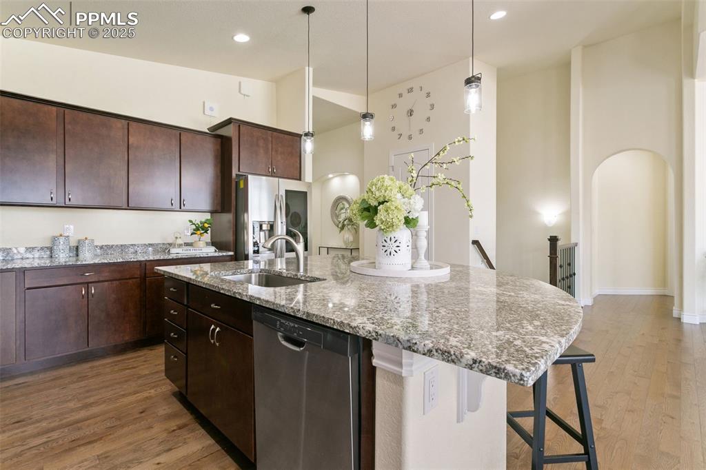 Image 18 of 49: Kitchen with rich cabinets, appliances with stainless steel finishes, light