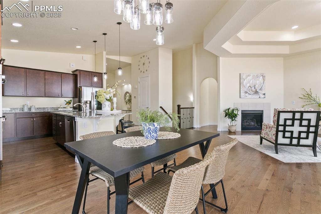 Image 19 of 49: Dining room with a tile fireplace, recessed lighting, light wood-type floor