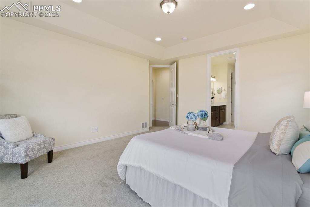 Image 24 of 49: Bedroom featuring recessed lighting, carpet floors, a raised ceiling, and e