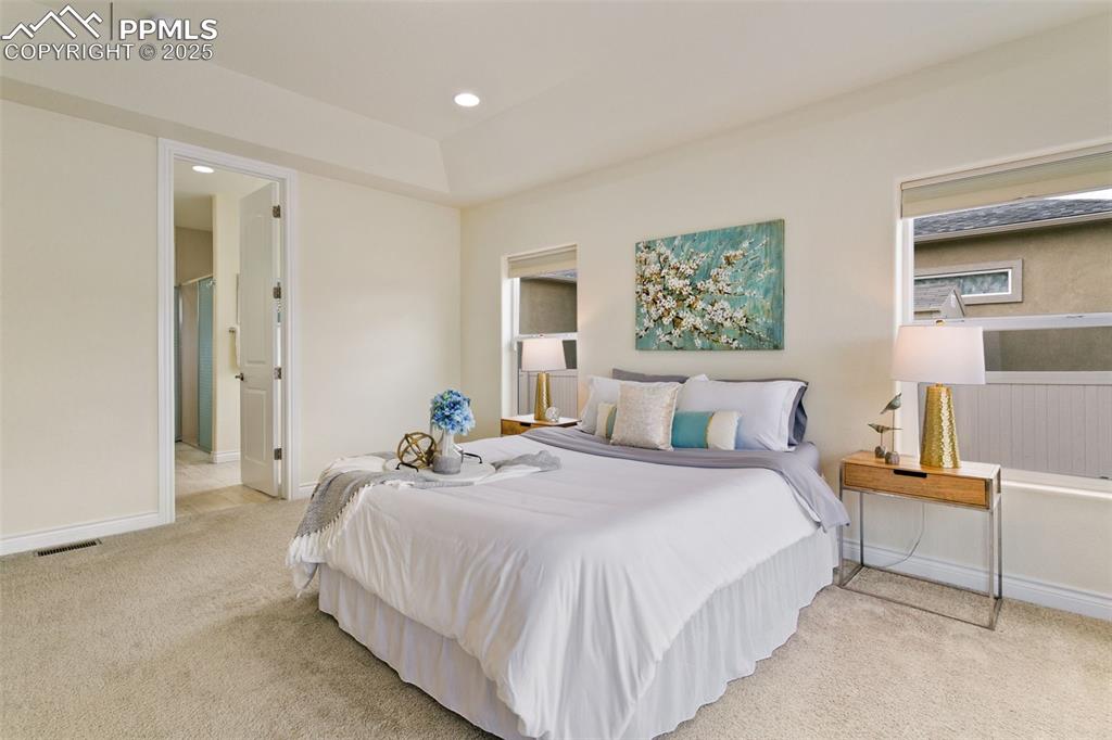 Image 25 of 49: Bedroom with light colored carpet and recessed lighting