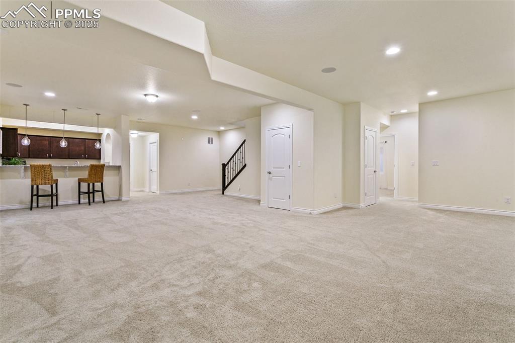 Image 26 of 49: Basement featuring recessed lighting, light colored carpet, and stairway