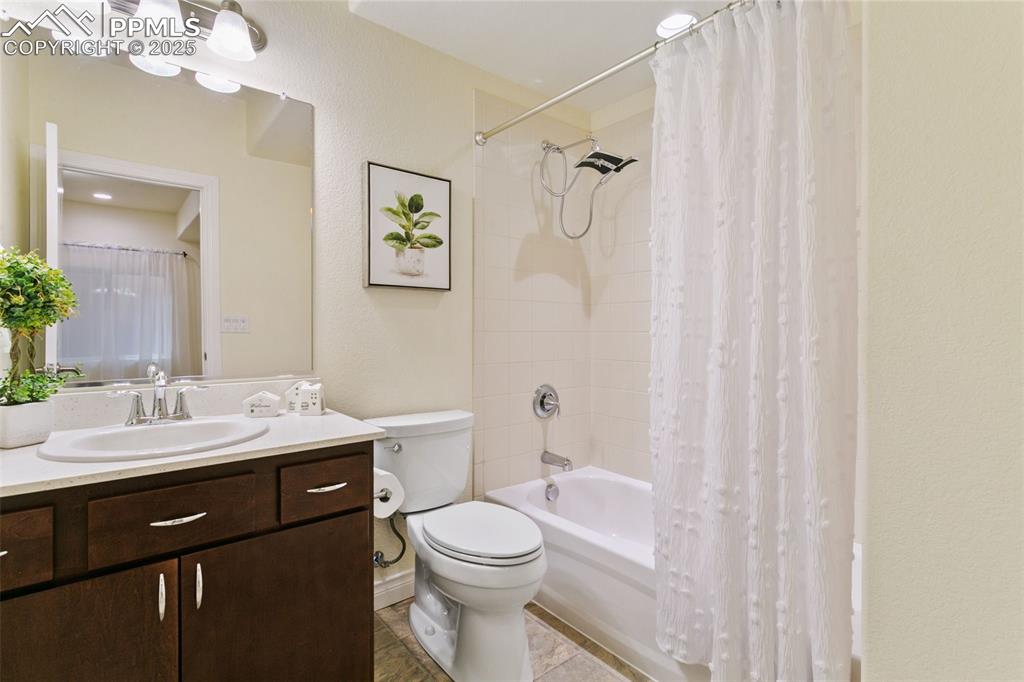 Image 34 of 49: Bathroom with shower / bath combo with shower curtain, vanity, tile pattern