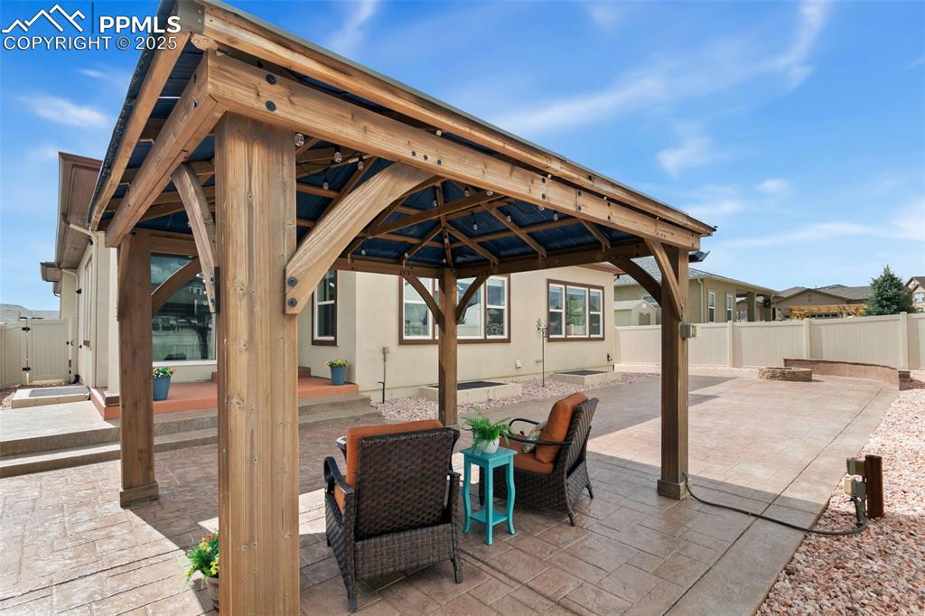 Image 37 of 49: Fenced backyard featuring a patio and a gazebo