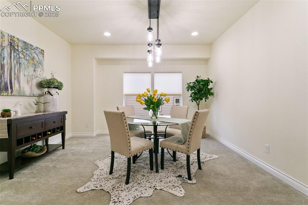 Image 4 of 49: Dining area with light carpet and recessed lighting