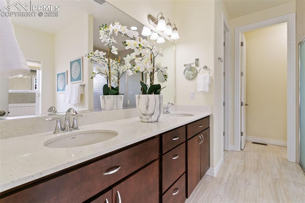 Image 8 of 49: Bathroom featuring double vanity and baseboards