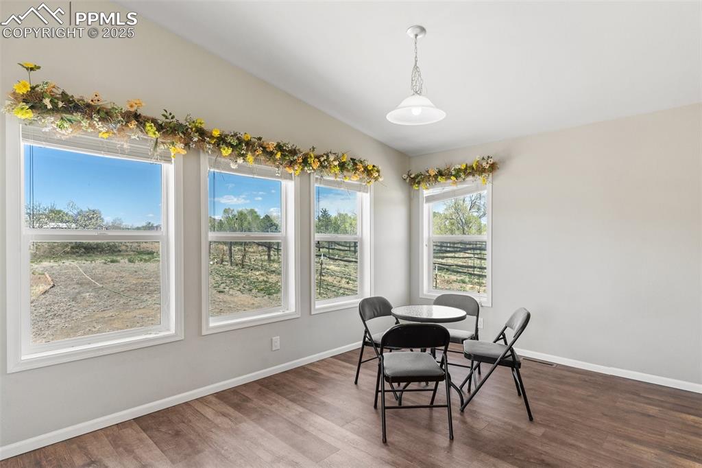 Image 16 of 50: Dining room featuring wood finished floors, lofted ceiling, and baseboards