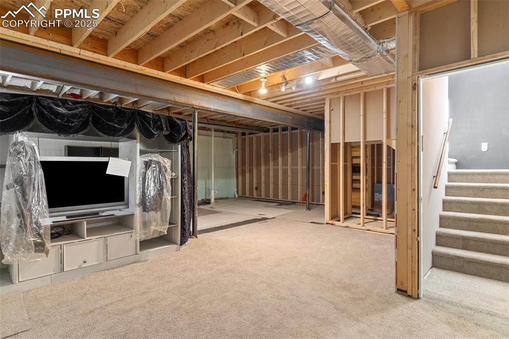 Image 25 of 50: Below grade area with carpet flooring and stairway