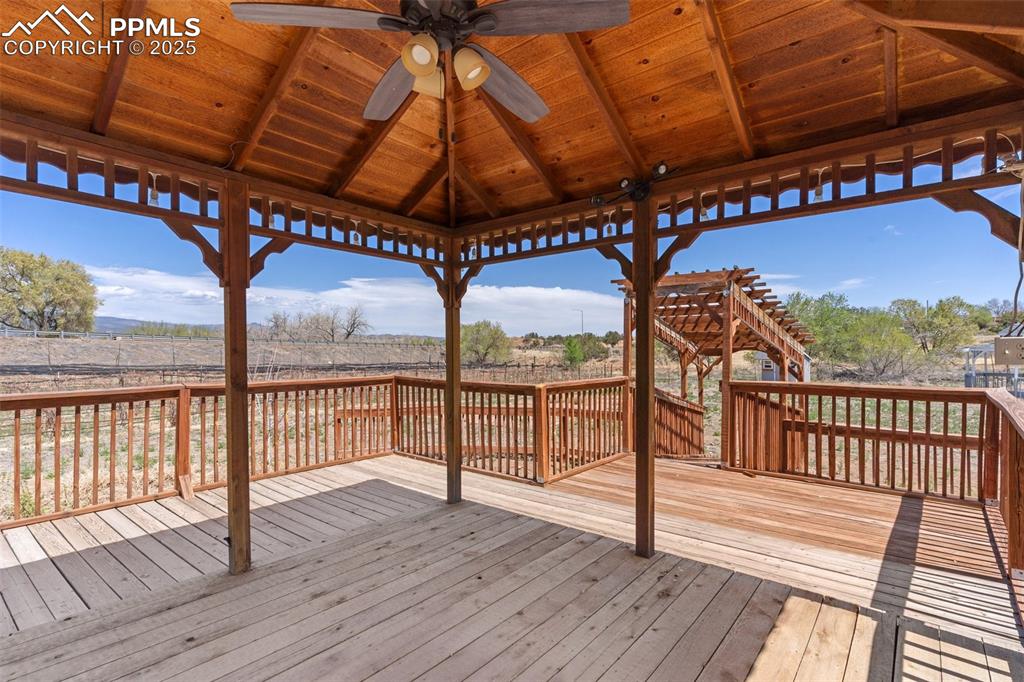 Image 34 of 50: Wooden terrace featuring ceiling fan