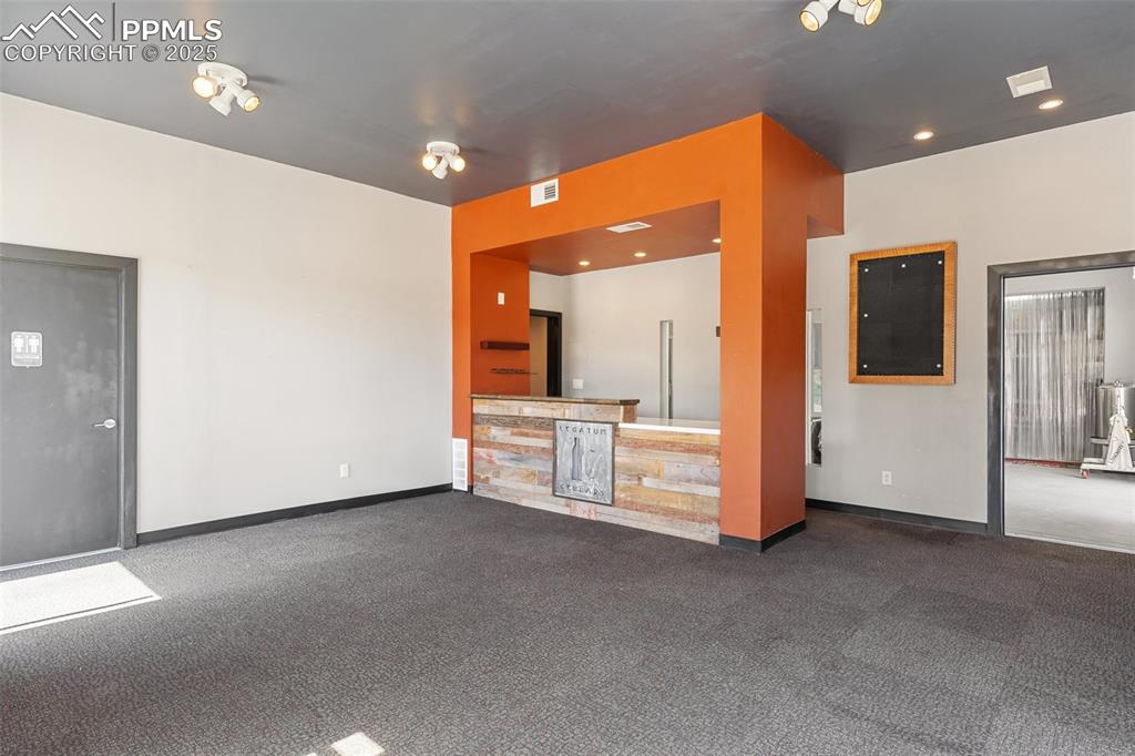 Image 38 of 50: Unfurnished living room featuring baseboards, visible vents, and carpet flo