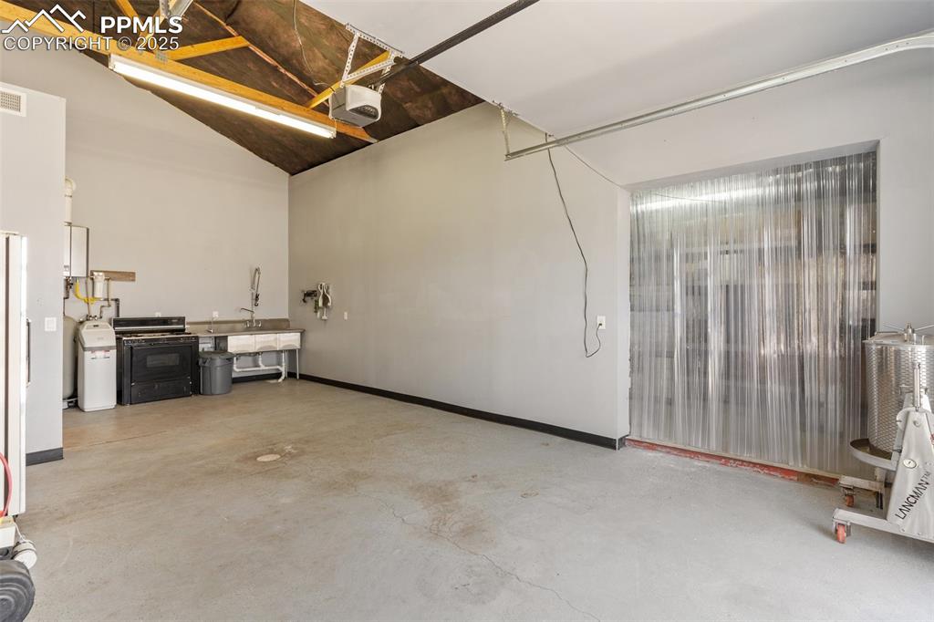 Image 43 of 50: Garage featuring visible vents, baseboards, and a garage door opener