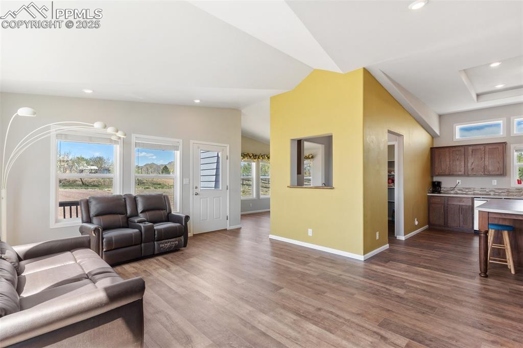 Image 7 of 50: Living room featuring recessed lighting, vaulted ceiling, baseboards, and d