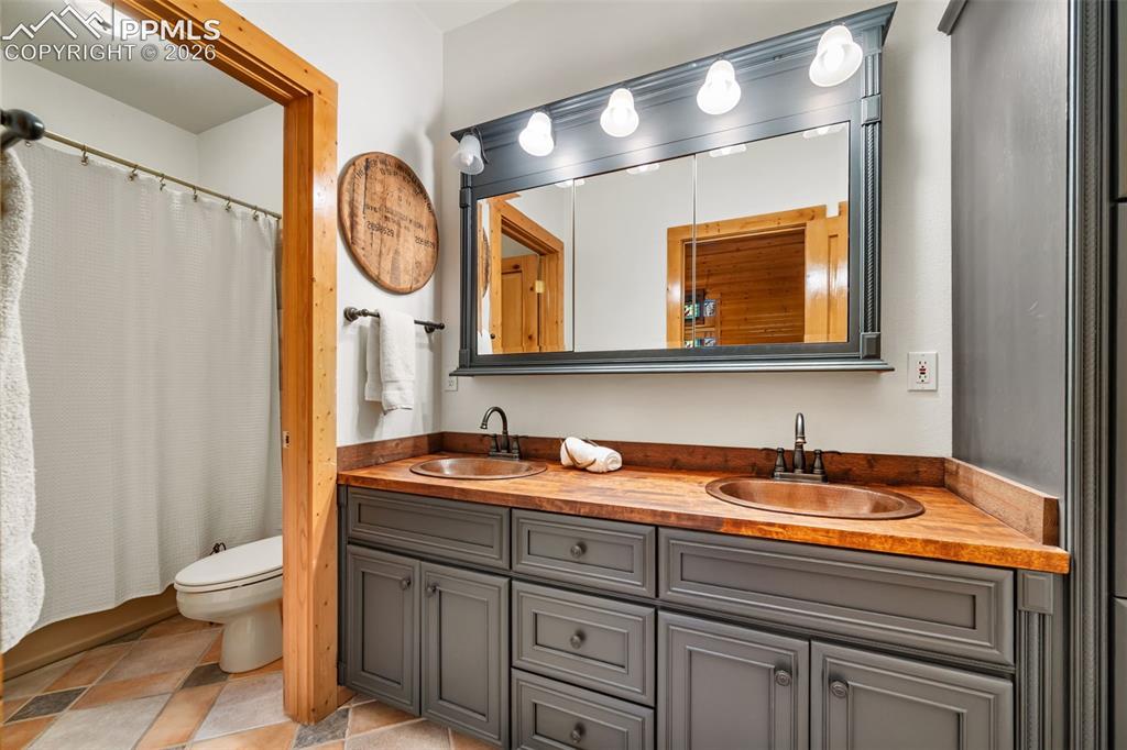 Image 15 of 34: Clean and functional, this bathroom features dual sinks, ample storage, and
