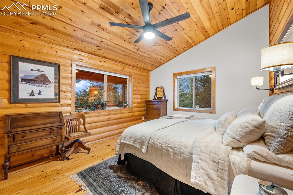 Image 16 of 34: Comfortable and inviting, this bedroom features warm wood finishes, vaulted