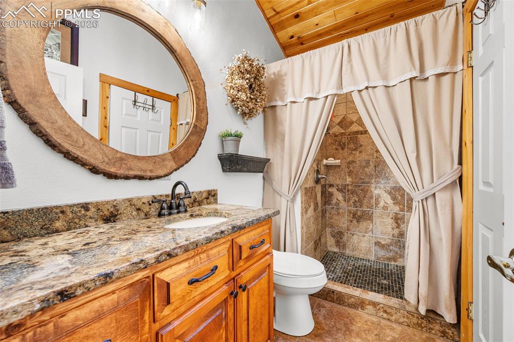 Image 17 of 34: Rustic and unique, this bathroom features warm finishes, a custom vanity, a