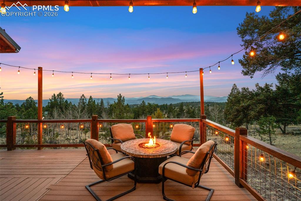 Image 19 of 34: Set against sweeping mountain views, this inviting deck offers a fire pit s