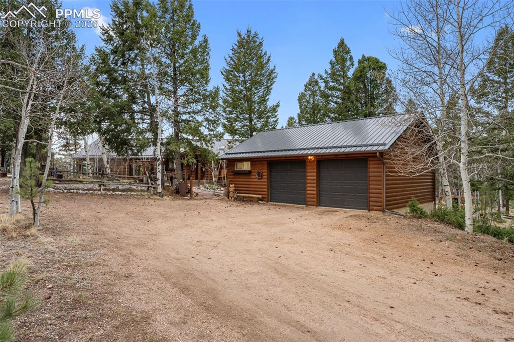Image 25 of 34: Detached garage offers ample space, set within a private and peaceful prope