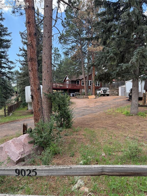 Image 17 of 23: View of front of house featuring a deck and driveway
