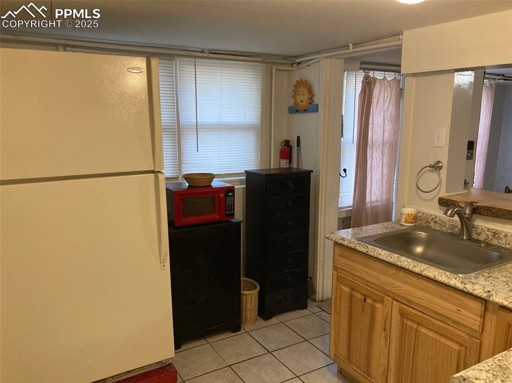 Image 21 of 23: Kitchen featuring freestanding refrigerator and light tile patterned floori