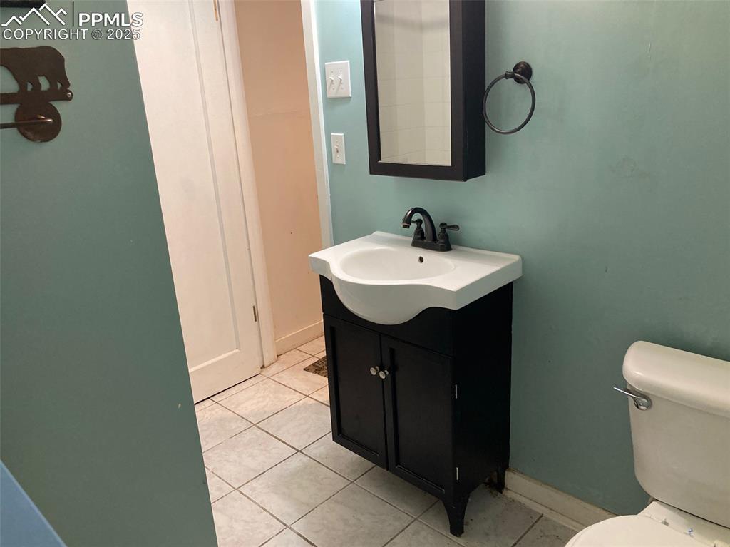 Image 22 of 23: Half bath featuring light tile patterned floors and vanity