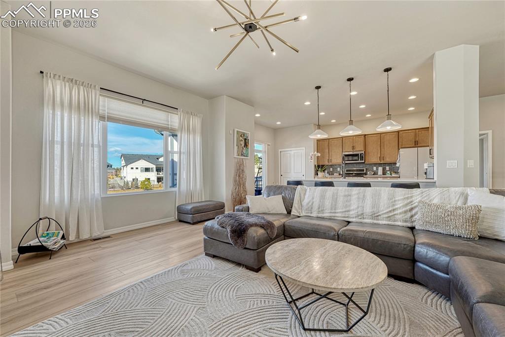 Image 11 of 50: Living room opens to kitchen with walkout to west facing deck