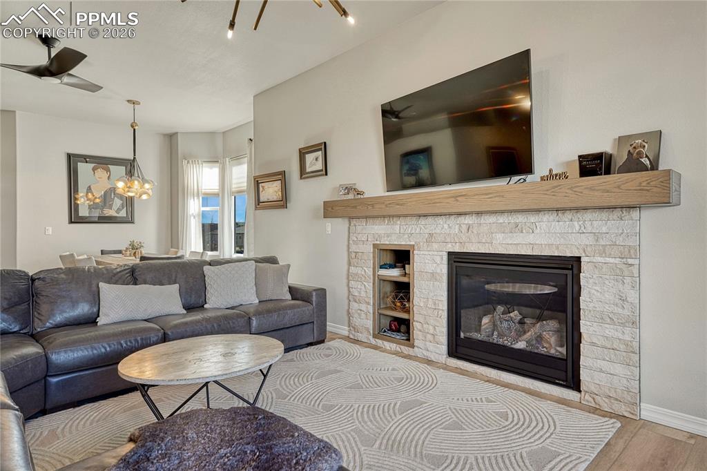 Image 4 of 50: Stone surround gas fireplace with chunky modern mantel