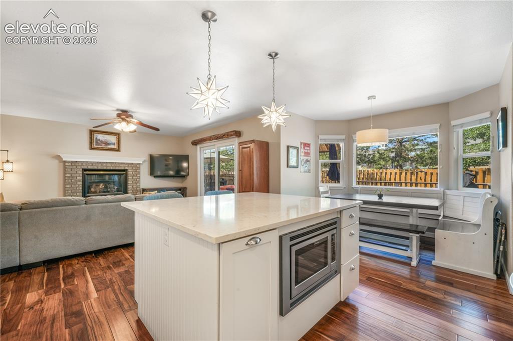 Image 16 of 50: Kitchen with large island with cabinet storage, quartz countertops, stainle