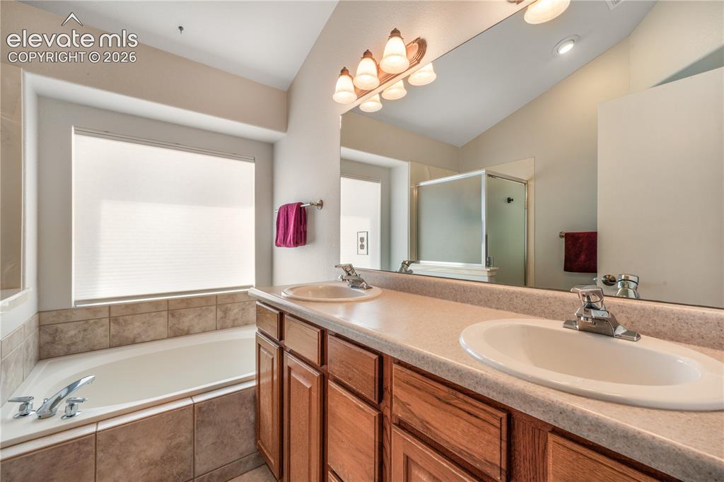 Image 30 of 50: Upstairs primary bedroom with large seating area, walk in closet and 5 piec