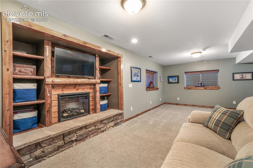 Image 39 of 50: Basement family room, built in entertainment area, electric fireplace inser