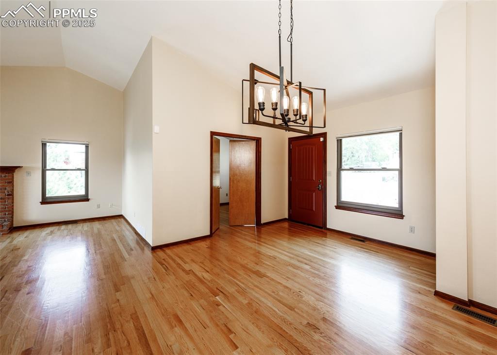 Image 16 of 44: Unfurnished dining area featuring light wood-type flooring, high vaulted ce