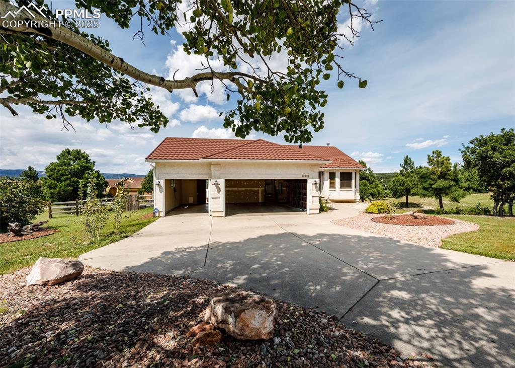 Image 3 of 44: View of front of house with concrete driveway, an attached garage, and a ti