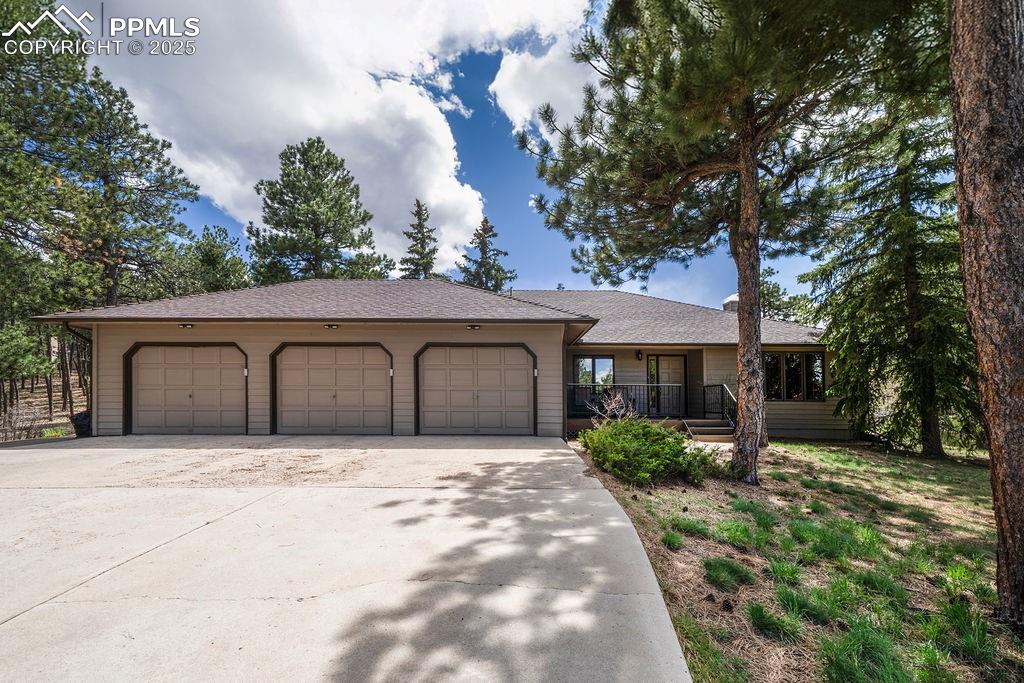 Caption: Single story home with a porch, a garage, and driveway