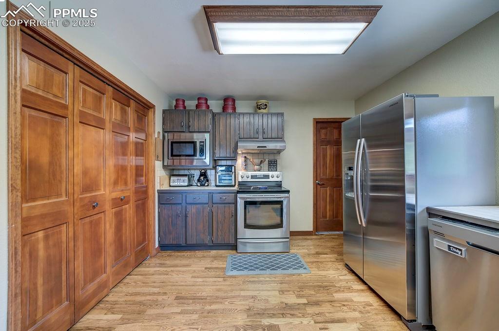 Image 10 of 42: Kitchen with under cabinet range hood, appliances with stainless steel fini