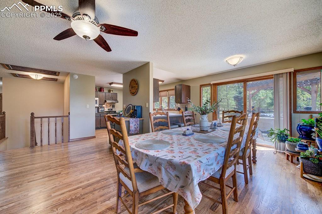 Image 14 of 42: Dining space featuring a textured ceiling, light wood-style flooring, and c