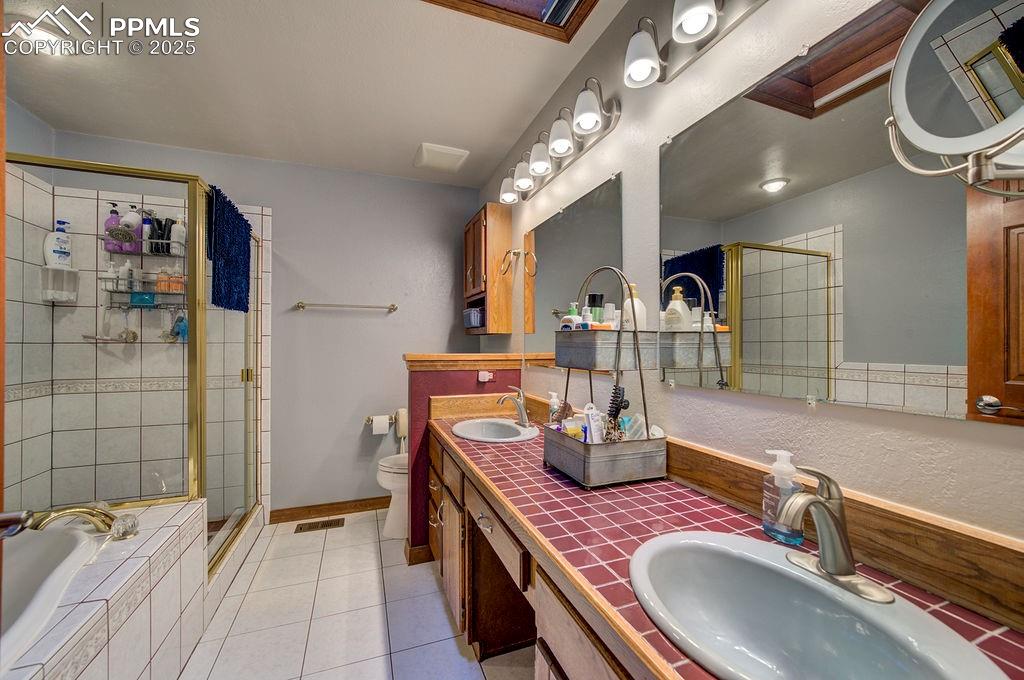 Image 16 of 42: Bathroom featuring tile patterned flooring, a sink, visible vents, and a sh