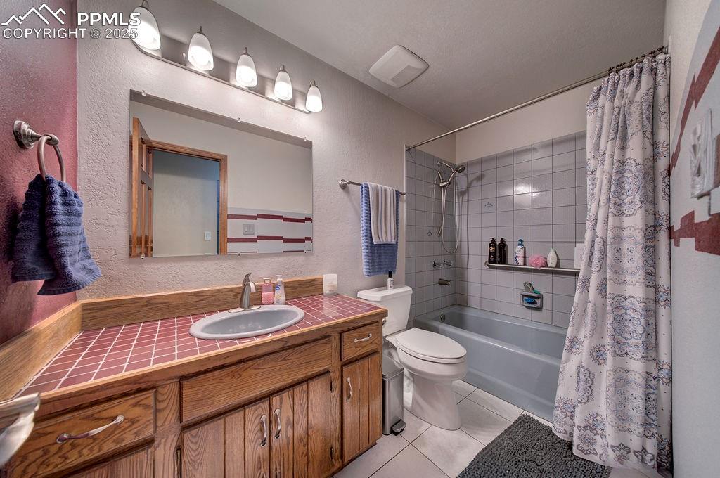 Image 18 of 42: Full bathroom with tile patterned flooring, shower / bath combo with shower
