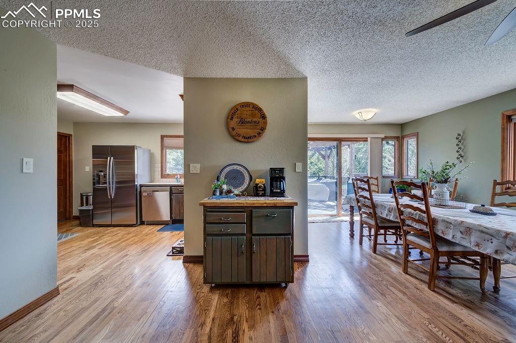 Image 27 of 42: Kitchen featuring light wood-style flooring, a textured ceiling, appliances