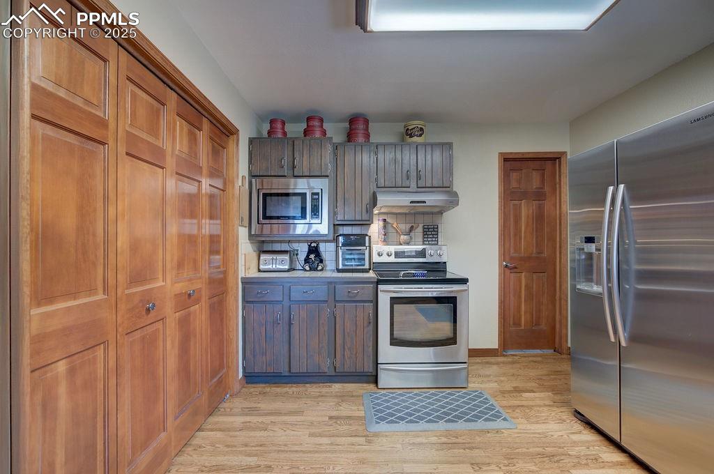 Image 28 of 42: Kitchen featuring light countertops, appliances with stainless steel finish
