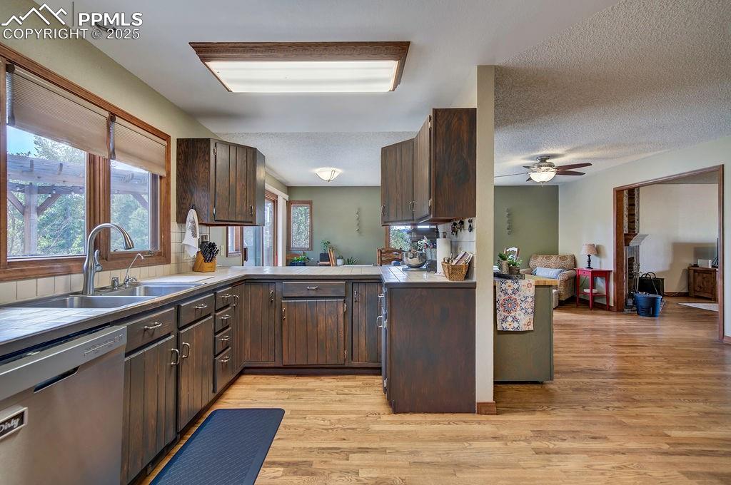 Image 29 of 42: Kitchen featuring stainless steel dishwasher, a sink, light wood-style floo