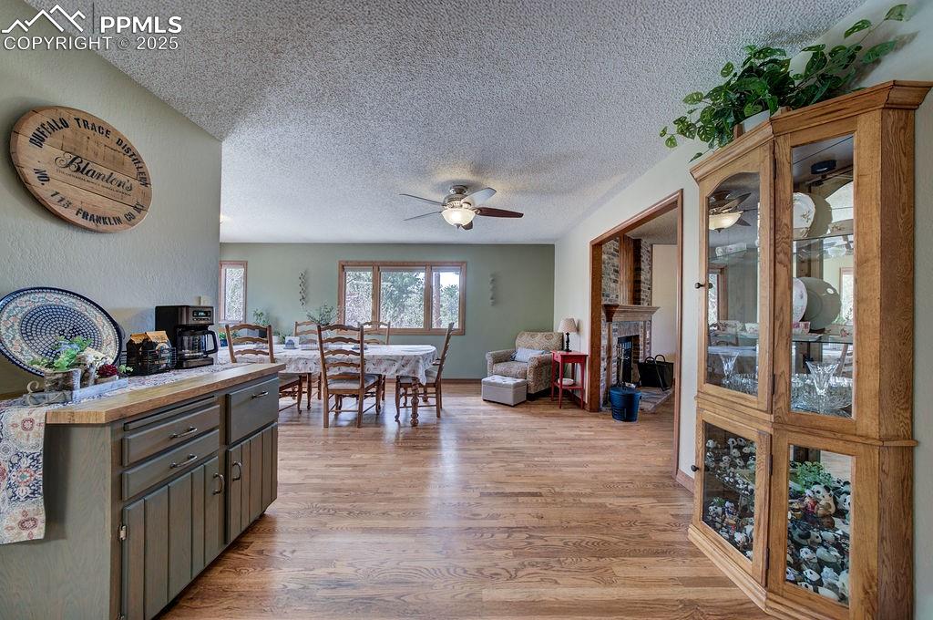 Image 9 of 42: Dining space featuring a ceiling fan, a textured ceiling, light wood-style