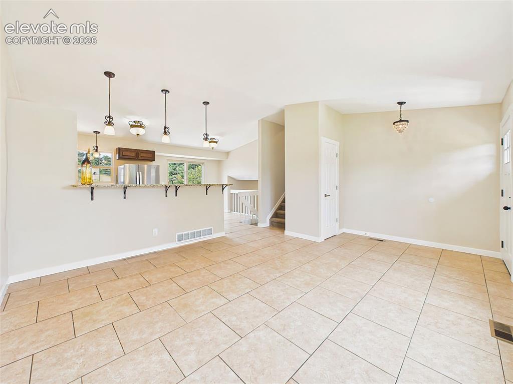 Image 11 of 50: Spacious open-concept living and dining area featuring durable tile floorin