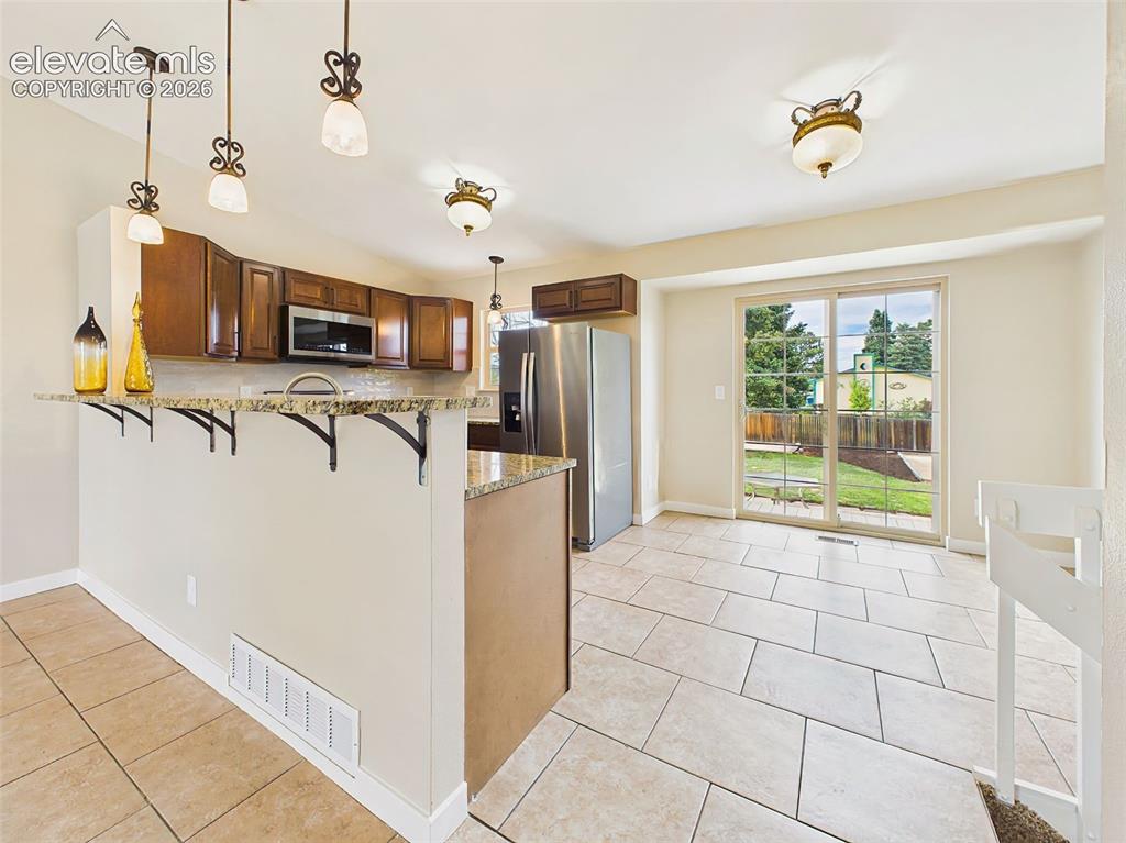 Image 13 of 50: Bright and functional kitchen offering stainless steel appliances, ample ca